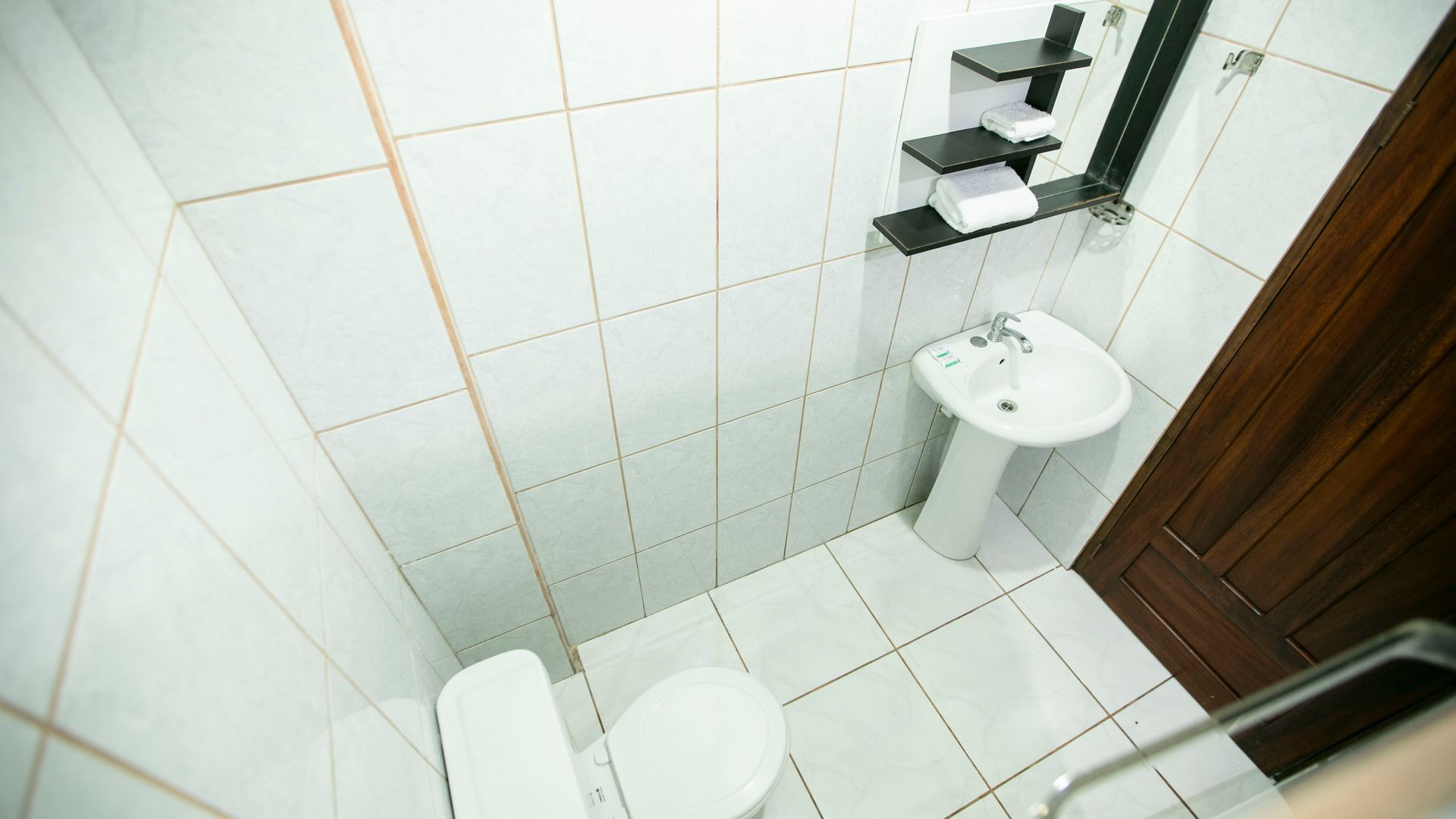 a bathroom with a toilet , sink and mirror .