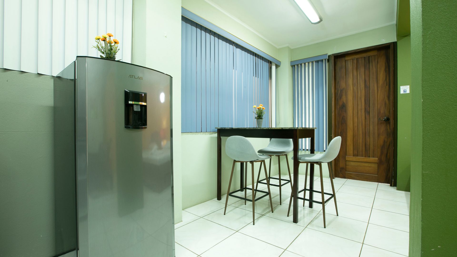 a kitchen with a table and chairs and a refrigerator .