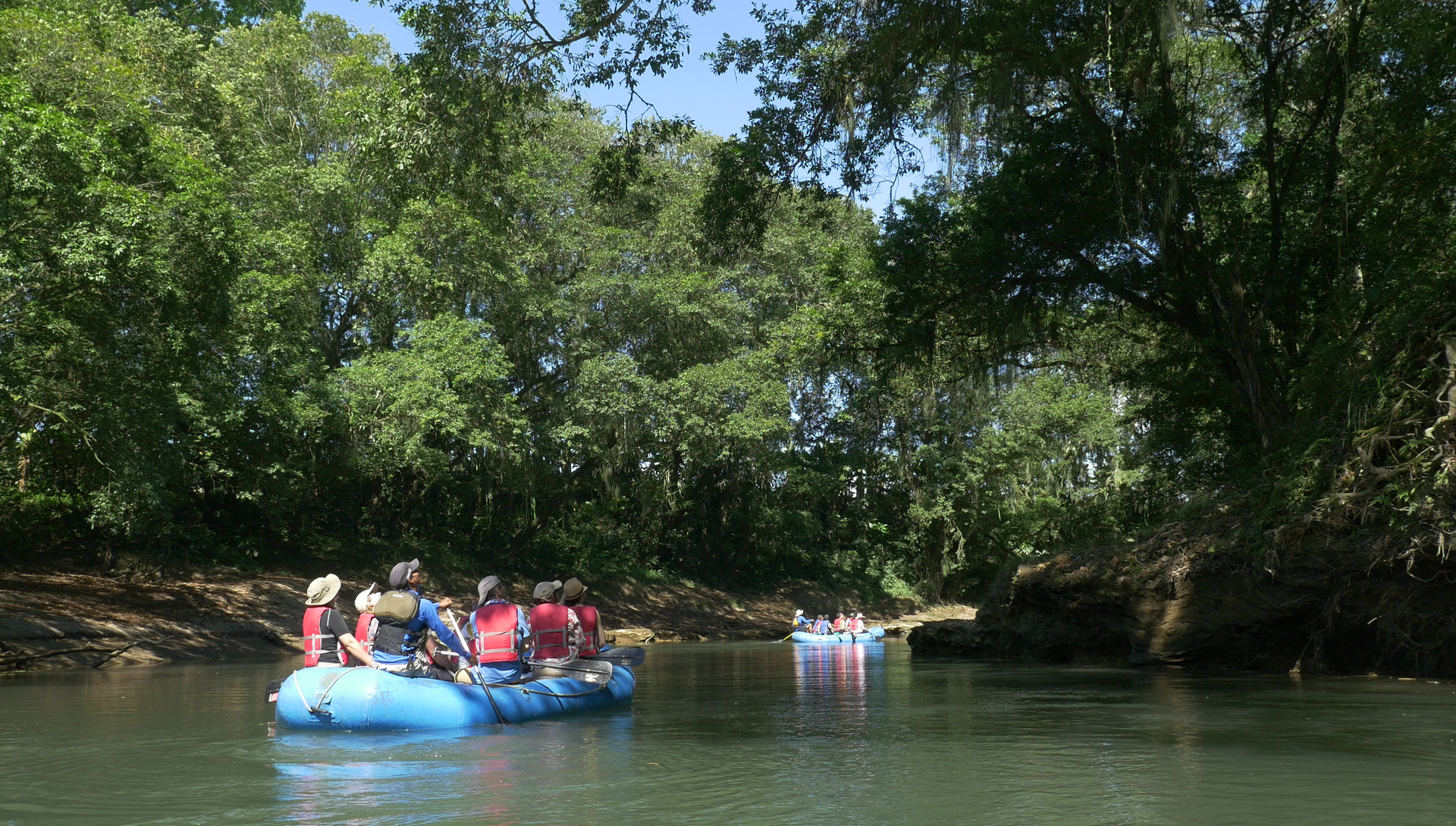 a group of people are rafting down a river .