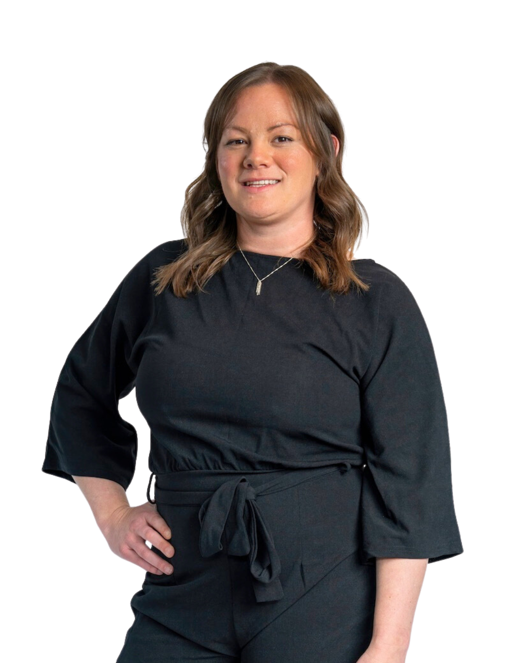 A woman in a black jumpsuit is standing with her hand on her hip.