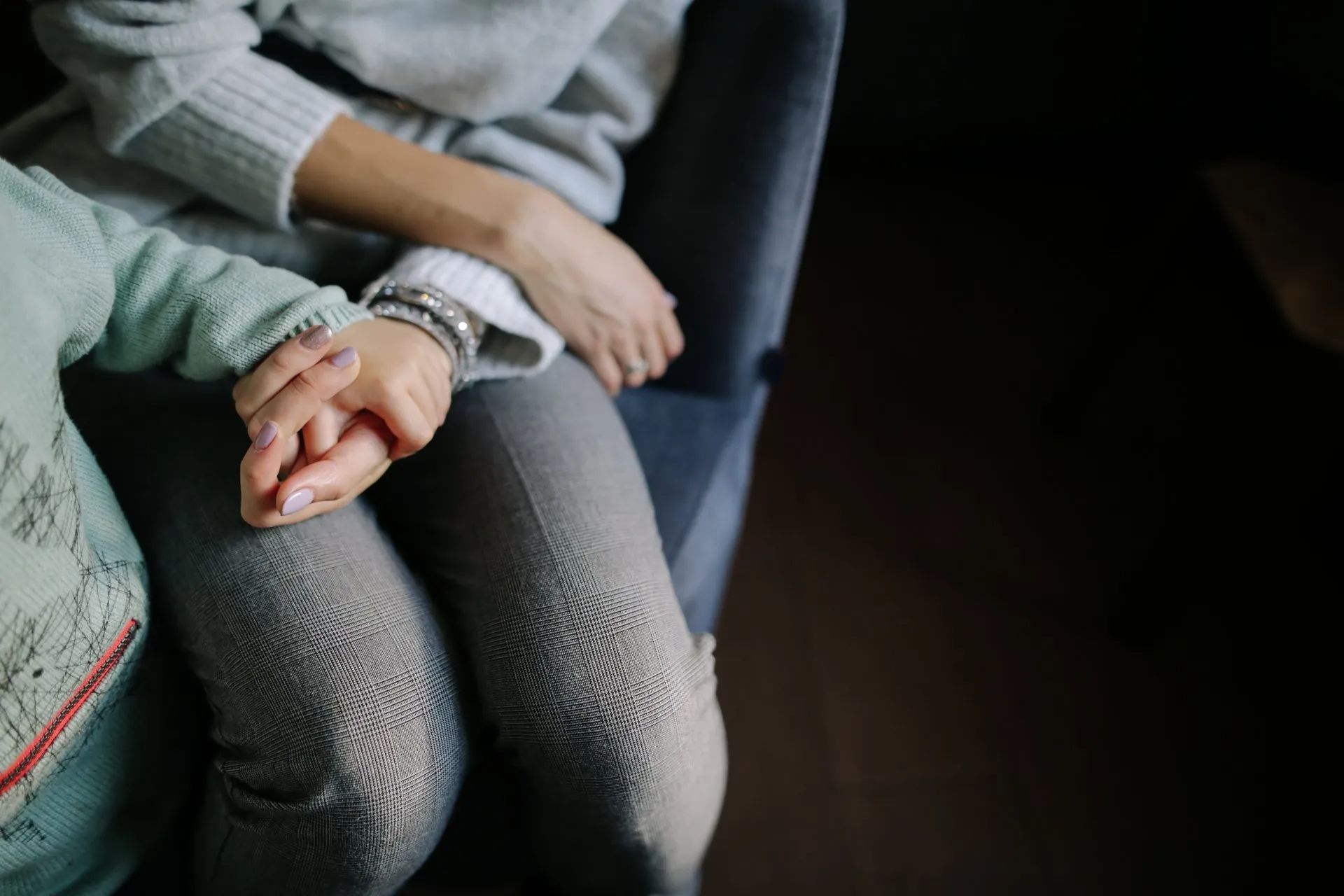 mother and child holding hands on couch
