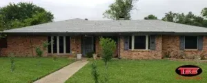 A brick house with a gray roof and black shutters