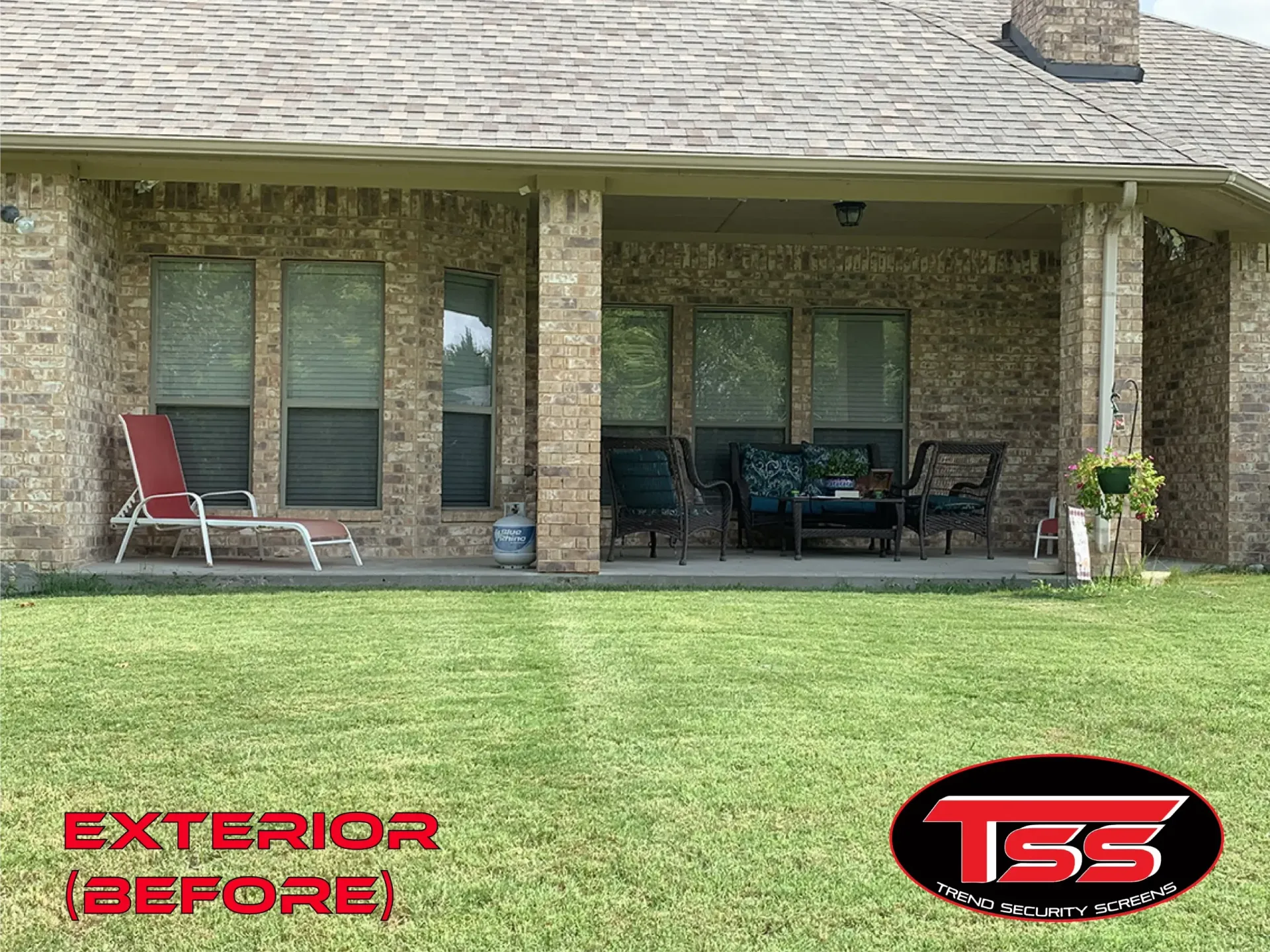 A brick house with a porch and chairs in front of it.