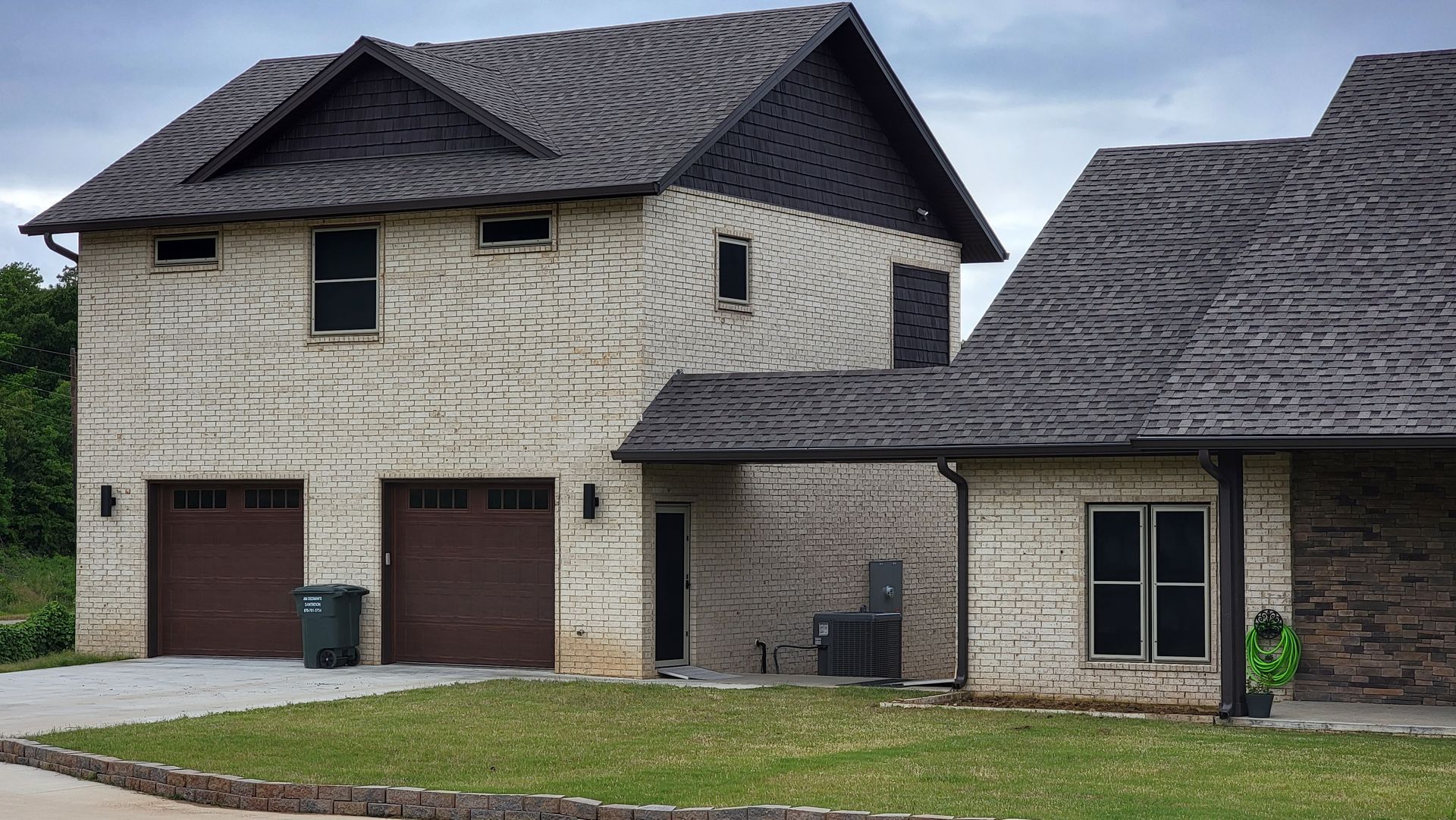 A house with two garage doors and a gray roof