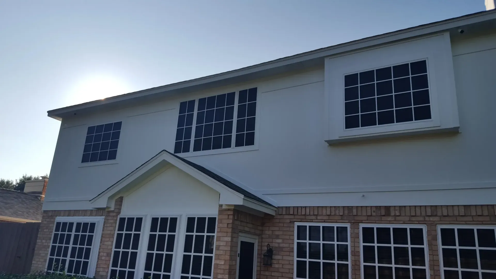 A large house with a lot of windows and a roof.