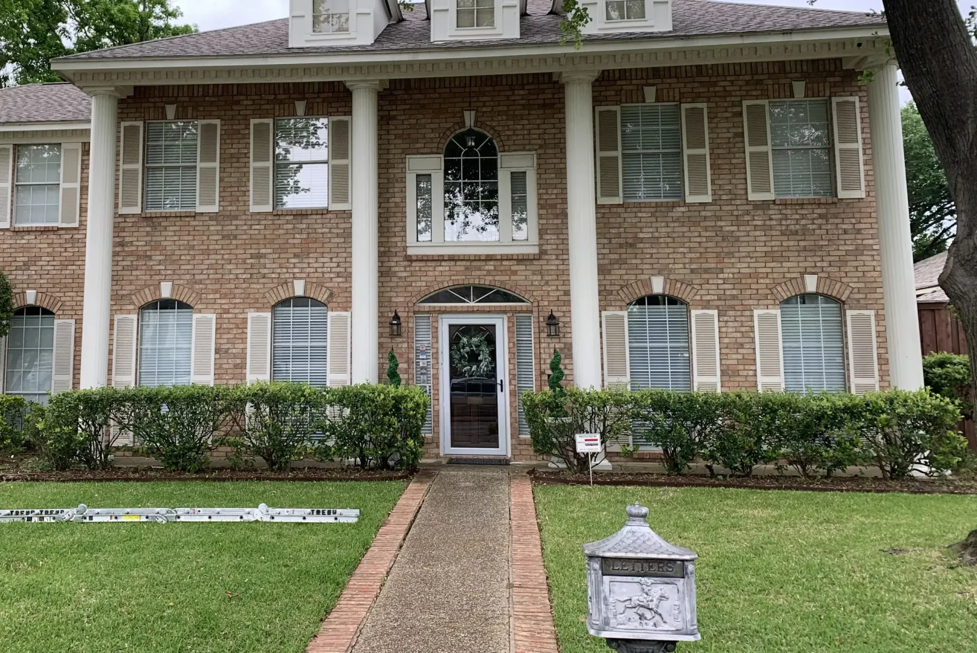 A large brick house with a mailbox in front of it.