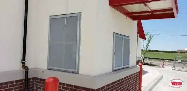 A white building with a red awning on top of it.