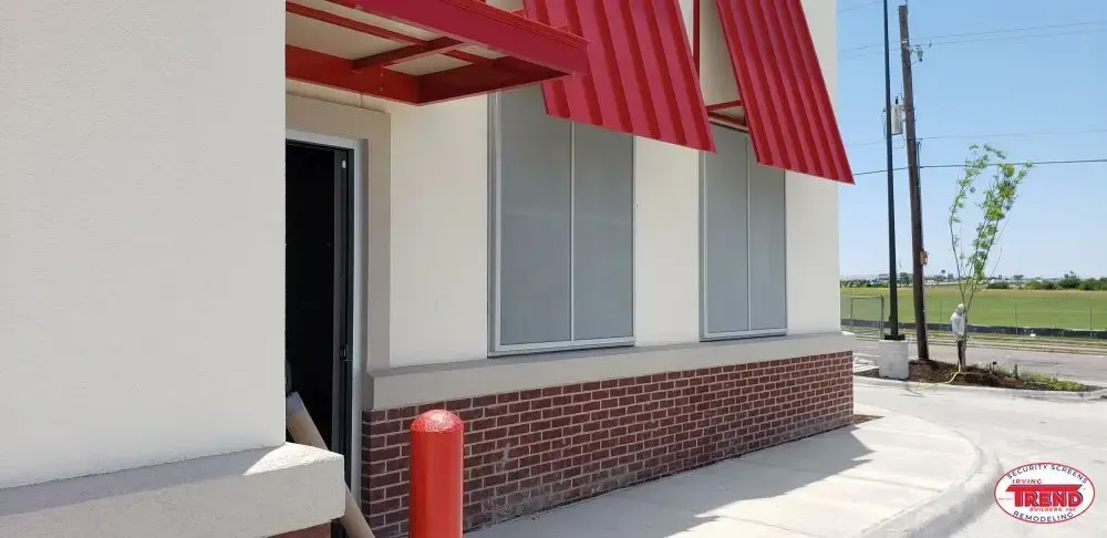 A white building with a red awning on the side of it.
