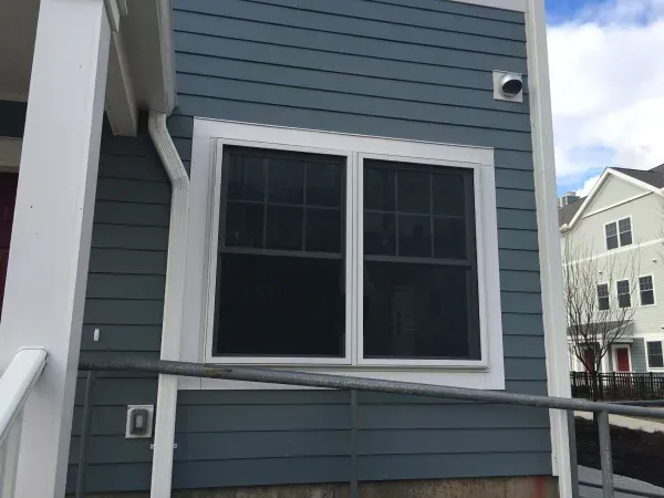 A blue house with two windows and a ramp