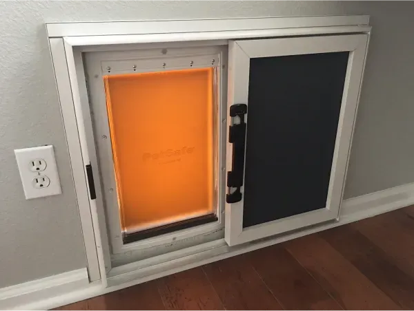 A dog door is built into a wall in a room