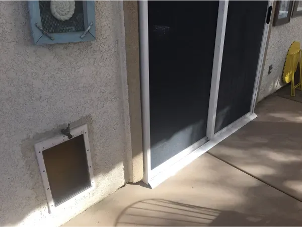 A sliding glass door with a cat door attached to it