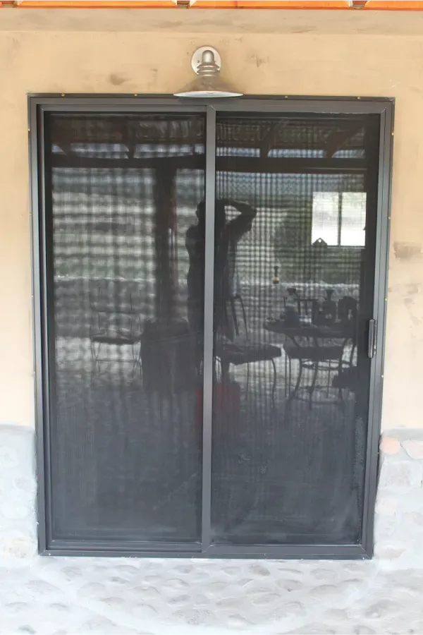 A sliding screen door is open to a patio