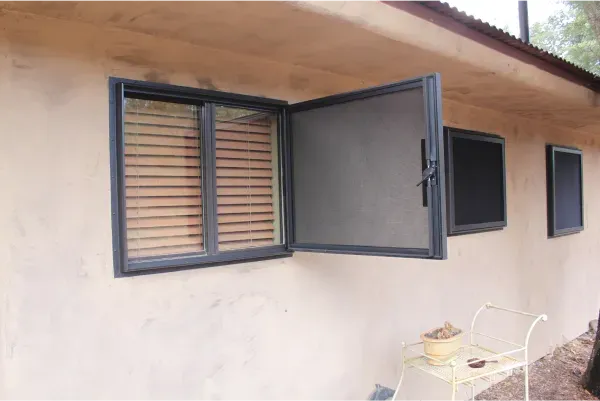 A house with a screened in window and shutters