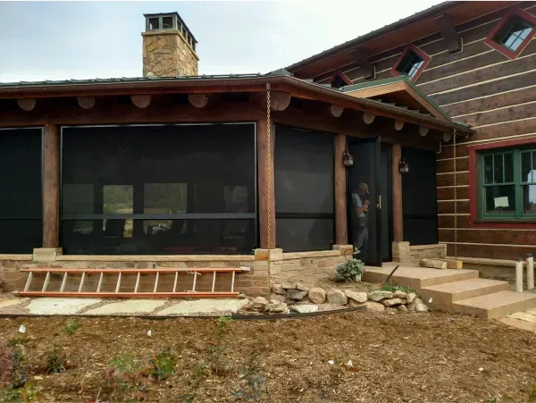 A screened in porch with a ladder in front of it
