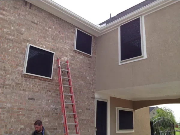 A man standing next to a ladder on the side of a house