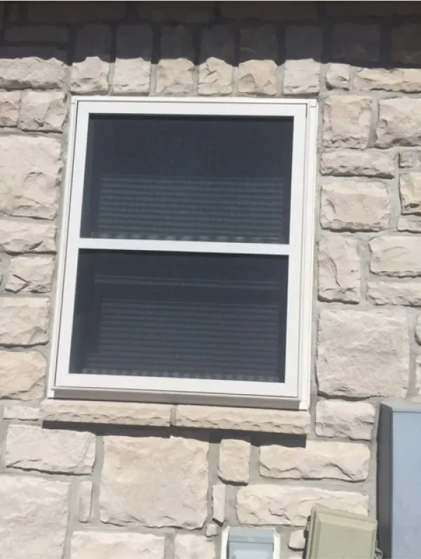 A window on a stone wall with a white frame