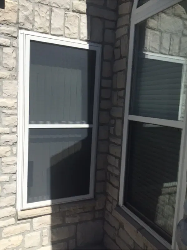 A corner of a brick building with two windows