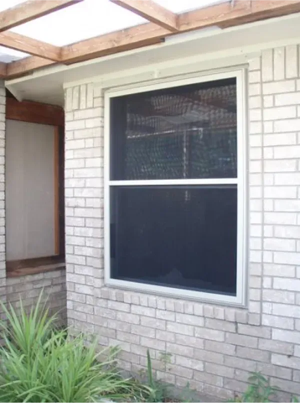 A white brick house with a large window