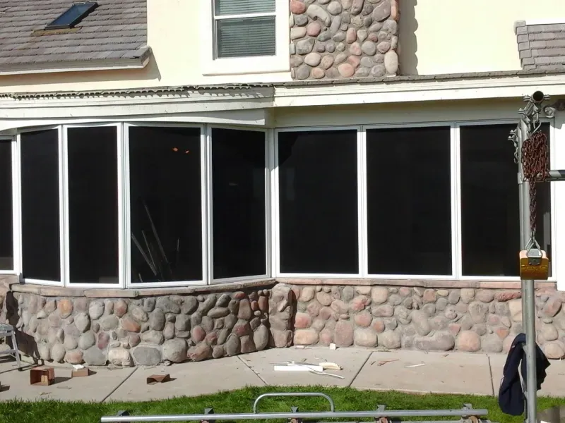 A house with a lot of windows and a stone wall