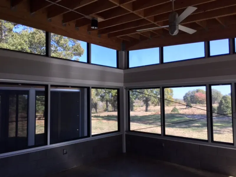 A room with a lot of windows and a ceiling fan