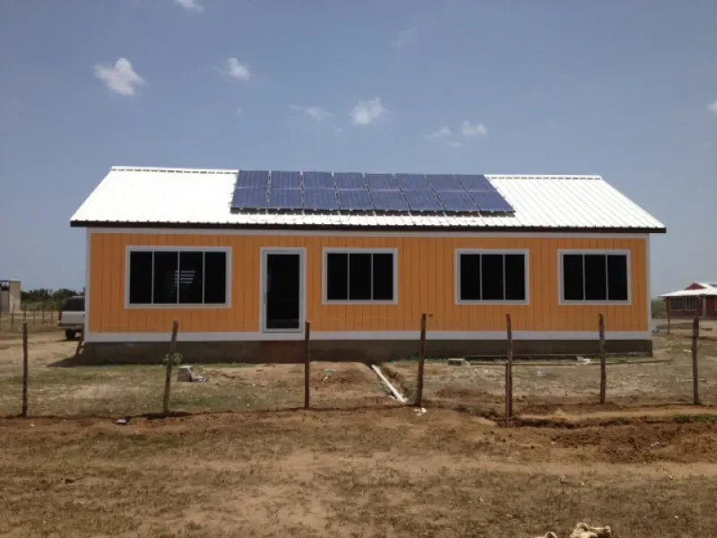 An orange house with solar panels on the roof