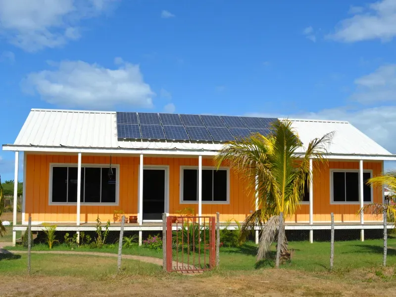 An orange house with solar panels on the roof