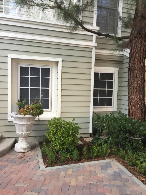A house with a planter in front of it and a tree in the background