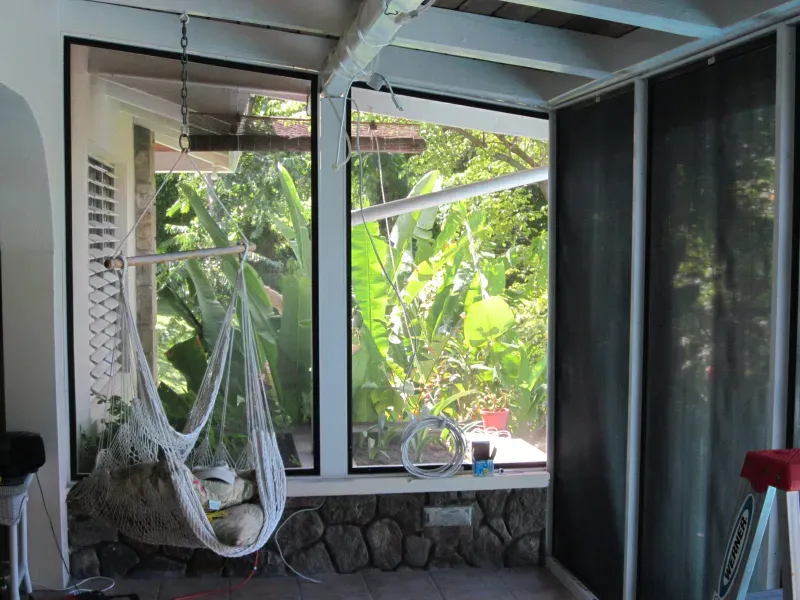 A hammock sits in front of a window in a room