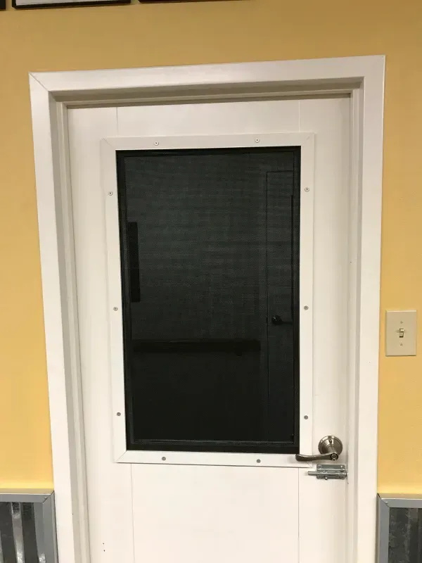 A white door with a glass window in a room.