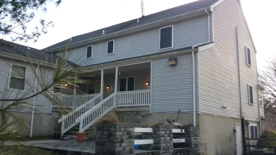 The back of a house with a porch and stairs.