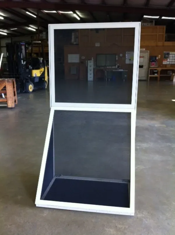 A screen door is open in a warehouse with a forklift in the background