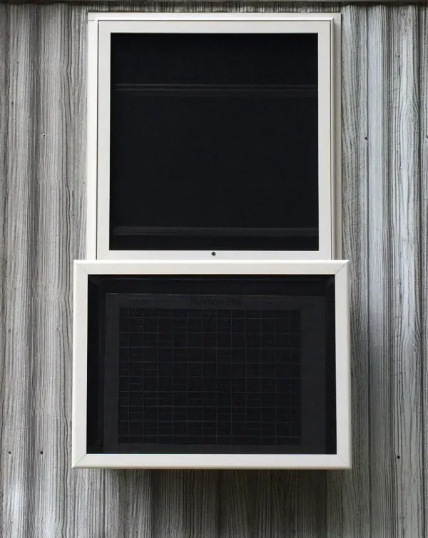 A white window with a black screen on a wooden wall.