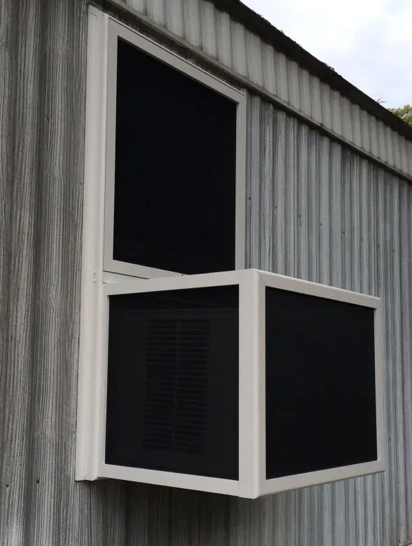 A white window with black screens on the side of a building