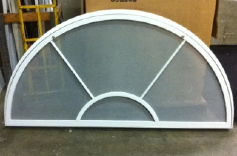 A white arched window with a screen on it