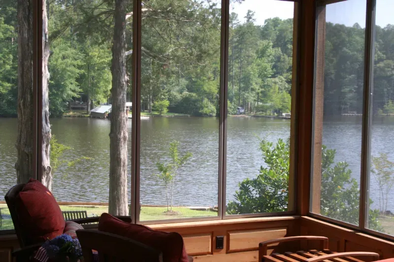 A screened in porch with a view of a lake