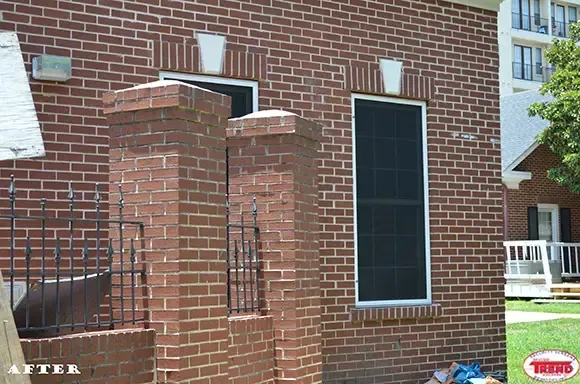 A picture of a brick house with a screened in window