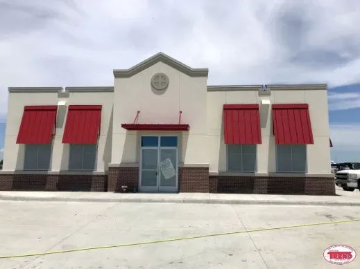 A white building with red awnings on the windows