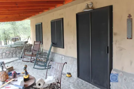 There are rocking chairs on the porch of a house.