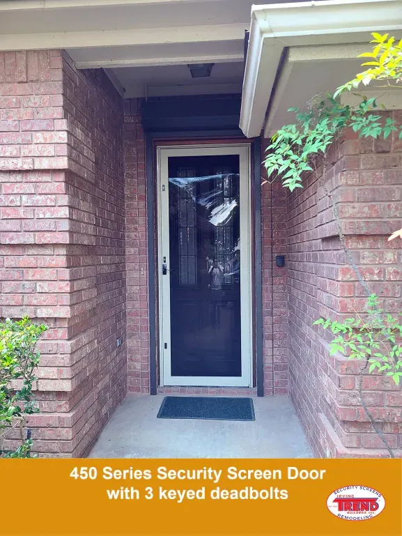 A brick house with a security screen door with 3 keyed deadbolts.