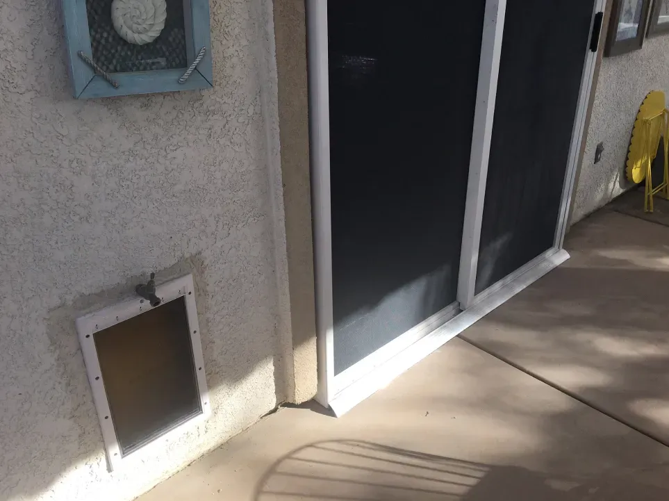 A dog door is built into the side of a sliding glass door.