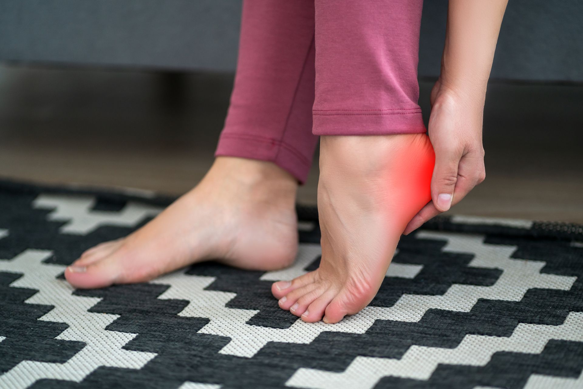 Person holding heel with highlighted pain area