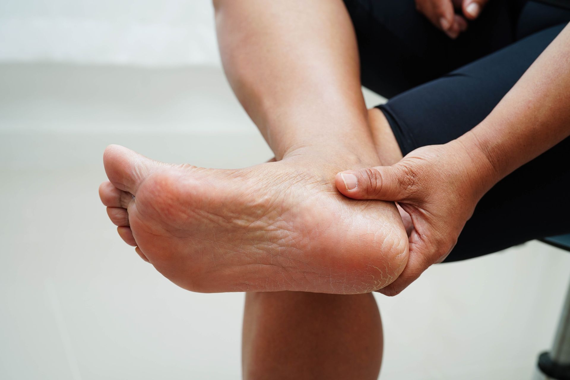 Person holding bottom of foot due to discomfort