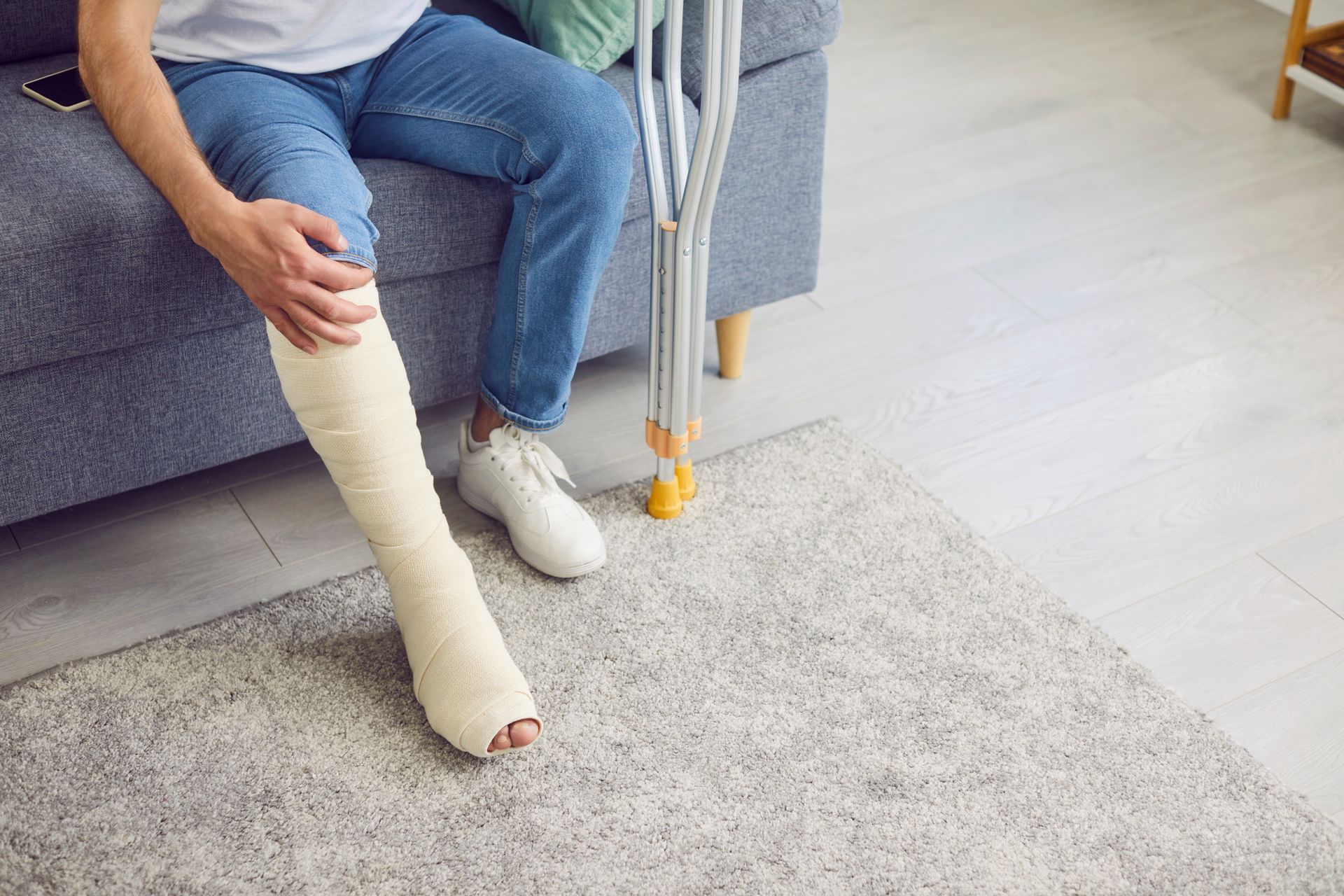 Patient with lower leg cast using crutches indoors