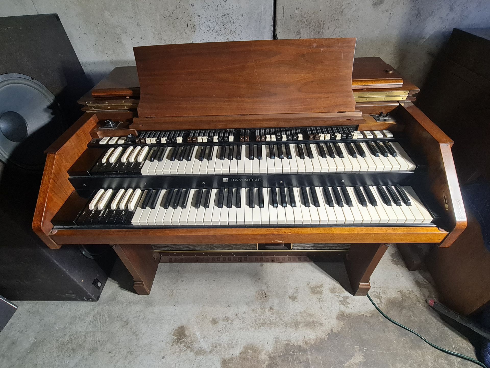 A wooden Hammond organ with two keyboards and a music stand, indoors.