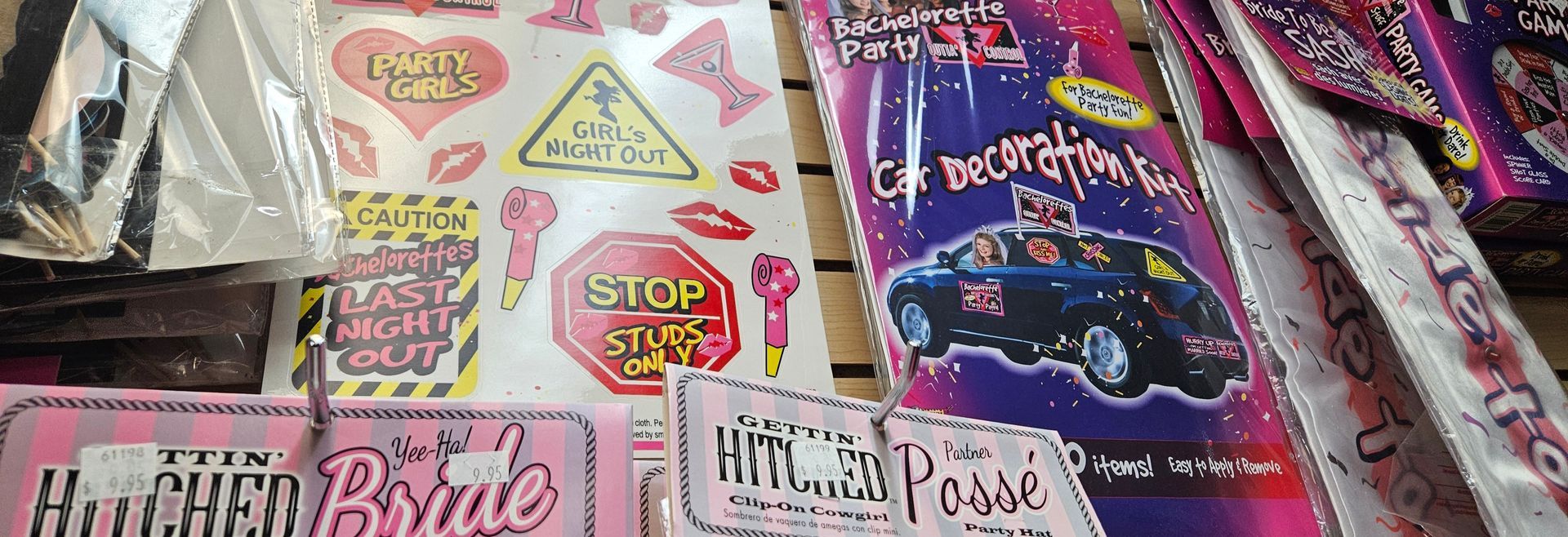 A display of bachelorette party supplies like hats, decor and car stickers.