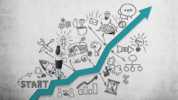 A woman is standing in front of a graph that says start