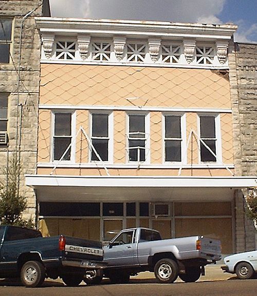 A chevrolet truck is parked in front of a building