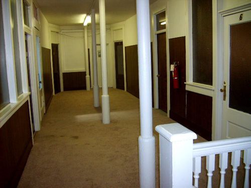 A long hallway with a fire extinguisher in the middle