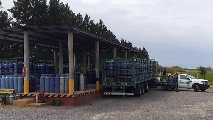 Un camión cargado con bombonas de gas azules 