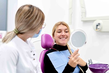 Woman Looking At Her Teeth After Treatment — Beatrice, NE — Pinkerton Dentistry Woman Looking At Her Teeth After Treatment — Beatrice, NE — Pinkerton Dentistry